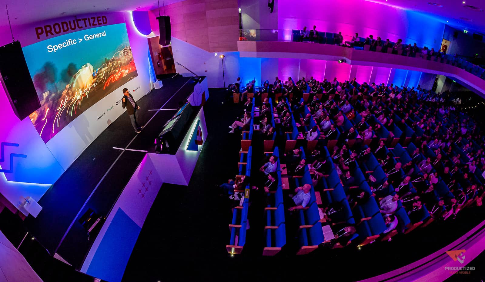 the venue and stage of the Productized conference, showing Steve Portigal on stage and the audience